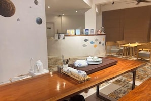 A dining area with a wooden table, chairs, and a buffet counter in the background.