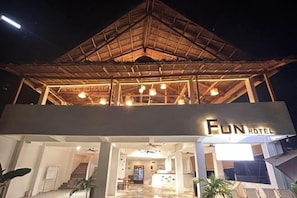 A hotel with a modern design, featuring a prominent sign 'FUN HOTEL' and a covered entrance area.