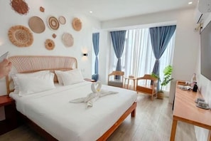 A hotel room with a bed, a desk, a chair, and a TV. - Fun Hotel (Panglao Municipality)