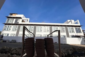 Un edificio moderno con tejado plano, ventanas amplias y fachada blanca.