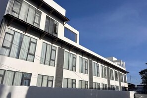 Ein mehrgeschossiges Gebäude mit großen Fenstern und einem Flachdach.