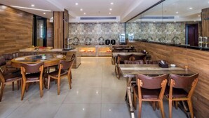 A modern restaurant with wooden flooring, round tables, and leather chairs. - Chonpines Hotel (Xinyu)