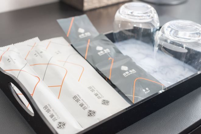 A tray with packaged items and clear plastic bottles, likely containing toiletries.