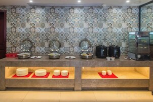 Montaje de bufé con varias estaciones de servicio, una máquina de café y un salpicadero de azulejos.