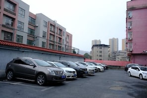 A parking lot with multiple cars parked in front of residential buildings.
