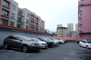 A parking lot with multiple cars parked in front of residential buildings.