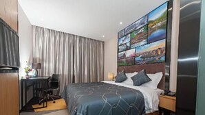 A hotel room with a bed, a desk, and a chair. - Chonpines Hotel (Xinyu)