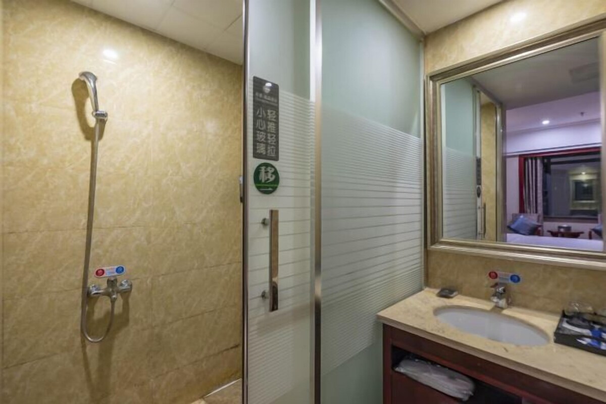 A bathroom with a glass shower enclosure, a sink with a mirror, and a towel rack.