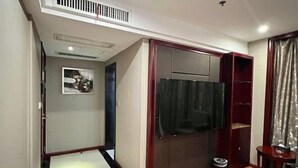 A compact room with a built-in wardrobe, a small trash bin, and a partial view of a curtain. - Chonpines Hotel (Xinyu)