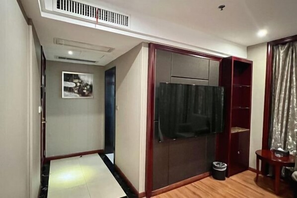 A compact room with a built-in wardrobe, a small trash bin, and a partial view of a curtain. - Chonpines Hotel (Xinyu)