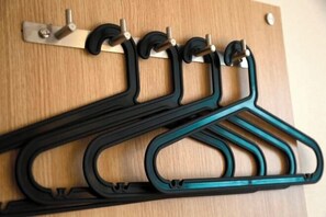 A wooden wall with a metal bracket holding black and teal hangers. - IU Hotel (Ancient City of Zhengding Rongguofu) (Zhengding)
