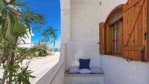 A narrow outdoor corridor with a bench and cushions, a wooden door, and a view of a street and buildings. - 4019 Villetta Biancamare by Barbarhouse (Carovigno)