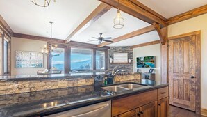 A kitchen with a stone backsplash, wooden cabinets, a stainless steel sink, and a ceiling fan. - Close to Skiing and Winter Sports, Gas Log Fireplace, Mtn View, Gated Resort, In (Boone)