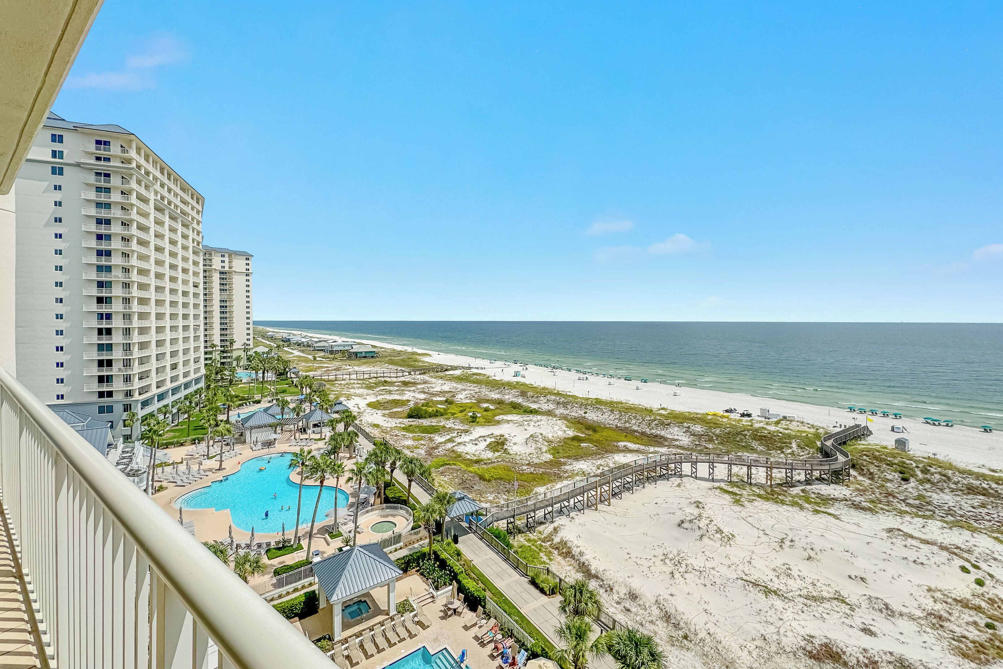 A resort with a pool, beach access, and a boardwalk.