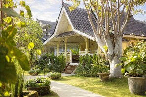 A traditional building with a tiled roof, surrounded by lush greenery and a pathway leading to the entrance. - Puri Tempo Doeloe Boutique Hotel (Bali)