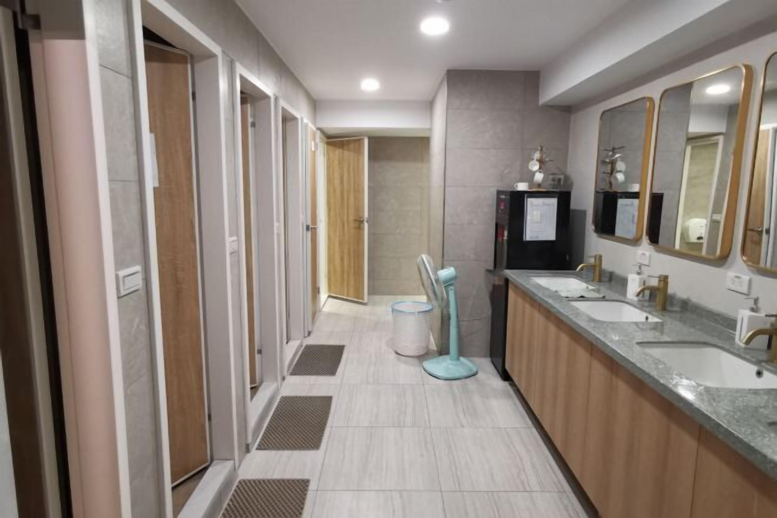A modern bathroom with three sinks, a vanity, and a mirror.