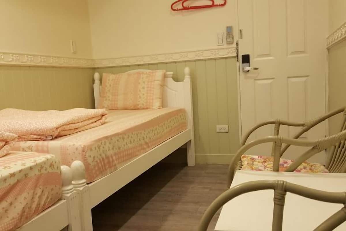 Un dormitorio pequeño y acogedor con una cama individual, una silla y una puerta.
