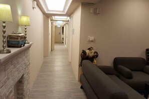 A hotel hallway with a fireplace, lamps, and a sofa. - TW Hostel 2 (Taipei)