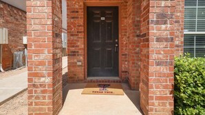 A brick building with a black door marked with the number 10. - Convenient Condo - 2BR 2 BA - Walk to Tech (Lubbock)