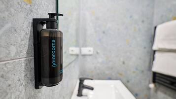 A bathroom with a wall-mounted soap dispenser and a sink.