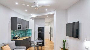 Een modern appartement met kitchenette, eethoek, zitkamer en slaapkamer.