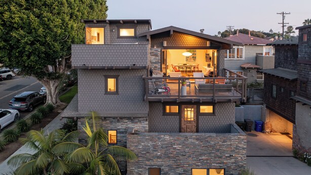 A modern two-story house with a balcony, stone facade, and a well-maintained garden. - Ocean View Craftsman Home - Great Location + Walk to Beach (Encinitas)