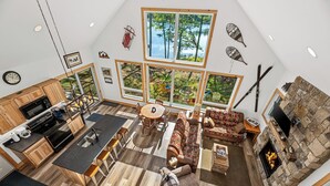 Amplio loft con cocina, comedor y sala de estar, que cuenta con ventanas grandes y una chimenea de piedra.