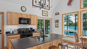 Una cocina moderna con armarios de madera, una isla central y vistas a una piscina.