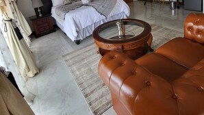 Una camera da letto moderna con un letto grande, una scrivania, una televisione e un divano in pelle.