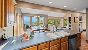 A kitchen with a large island, double sinks, and a view of the outdoors. - Wanderlust •HotTub •Spa Room w/Sauna •2 King Suites (Gatlinburg)
