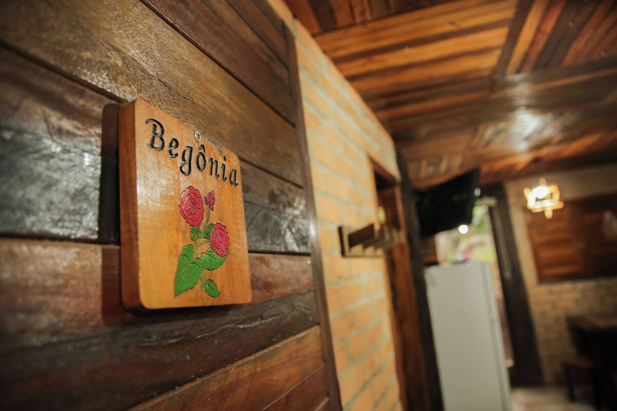 A wooden wall with a sign that reads "Begonia" and a rose illustration.