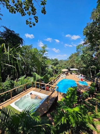 Una piscina al aire libre, sombrillas, sillones reclinables de piscina