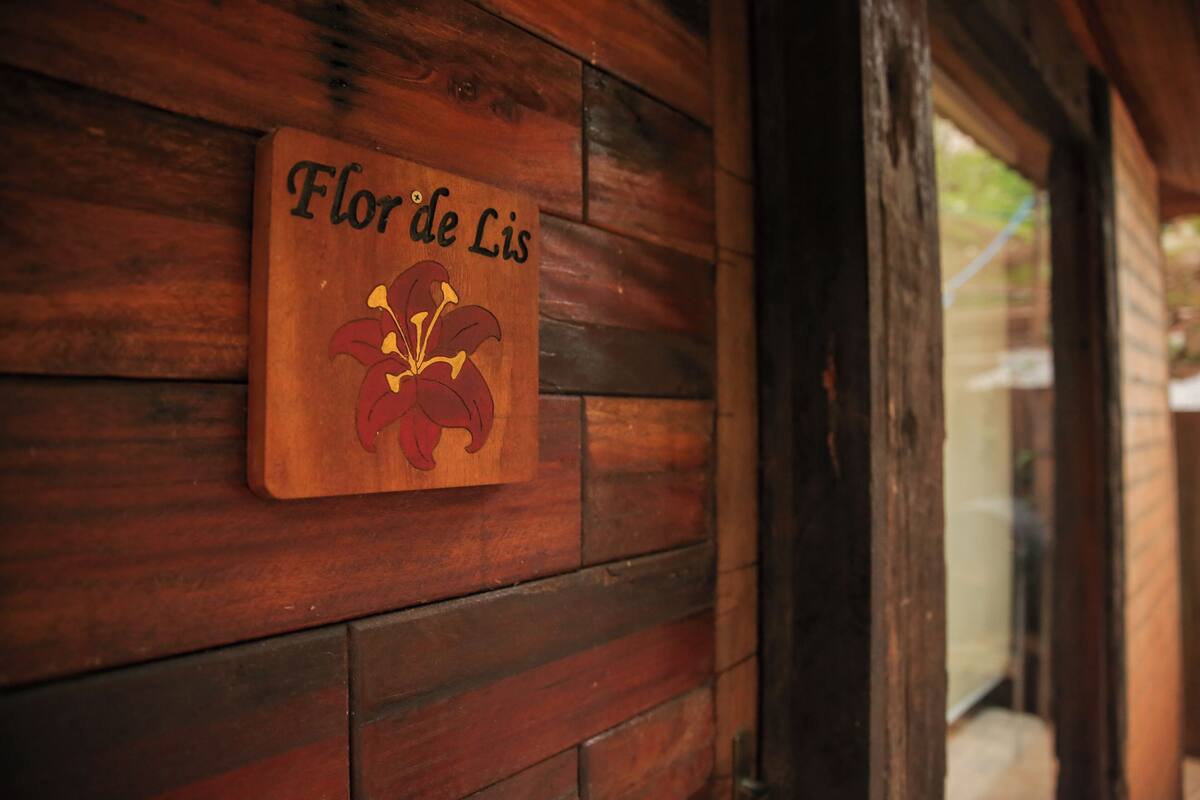 A wooden wall with a plaque that reads "Flor de Lis".