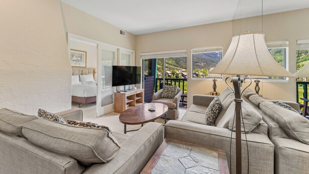 A modern living room with a sofa set, a TV, and a lamp. - Private Balcony w/ Golf Course & Slope Views, Short Walk to Shuttle Stop! (Copper Mountain)