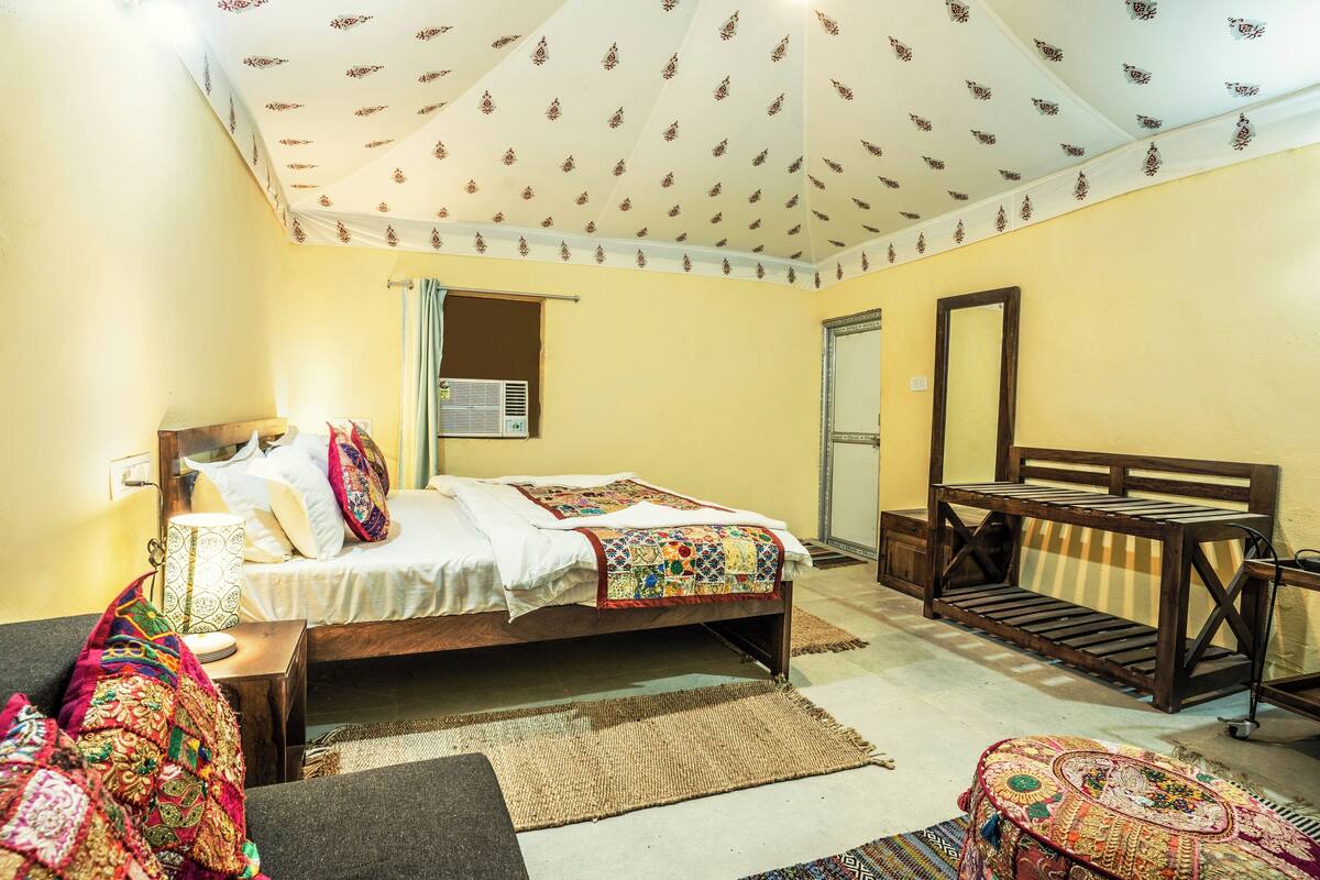 A bedroom with a bed, bedside table, and a bench.