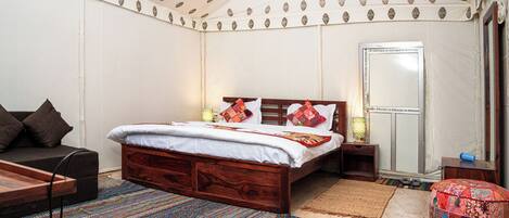 Un dormitorio con cama de madera, un sofá, un tapete estampado y un techo decorativo.