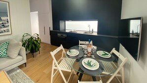 A modern kitchen with dark cabinetry, a built-in oven, and a window above the sink.