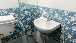 Une salle de bain avec des toilettes, un lavabo et des carreaux bleus à motifs.