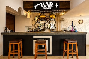 A bar counter with a sign reading 'BAR COUNTER,' a selection of bottles, glasses, and a hookah. - Holiday Beach Resort (Candolim)