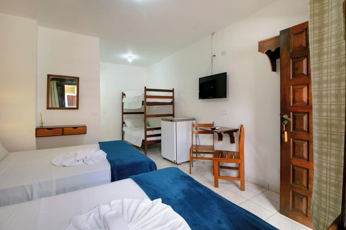 A room with two beds, a desk, a TV, and a door.