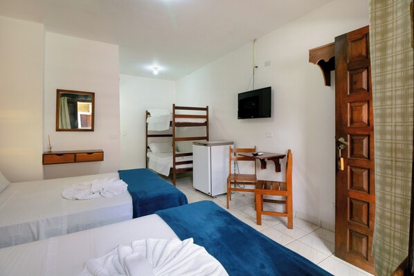 A room with two beds, a desk, a TV, and a door. - VELINN Pousada Ubatuba Tropical (Ubatuba)