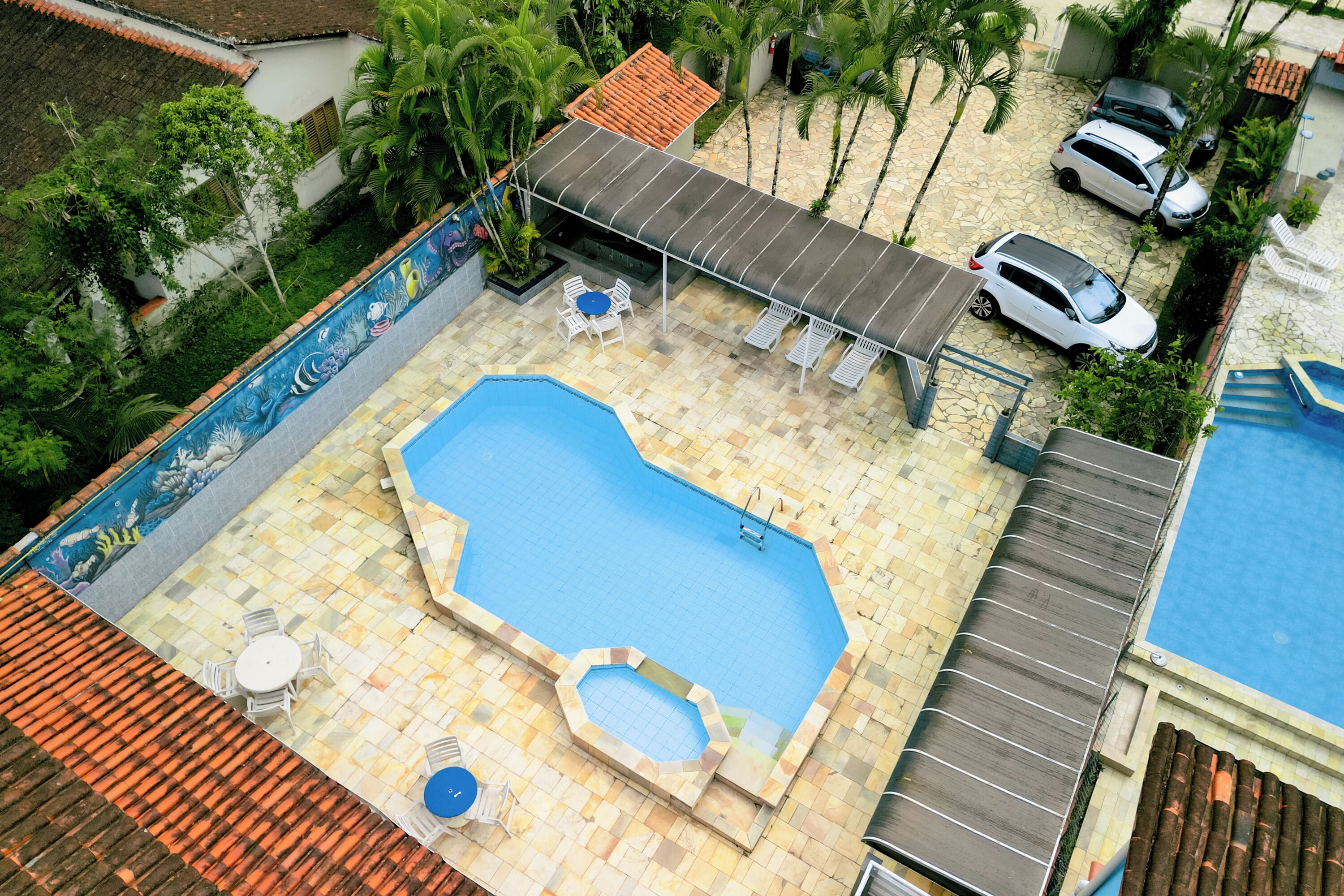 Ein Dachpool mit Sonnenschutz, eine kleine Whirlwanne und eine Sitzgruppe mit Stühlen.