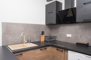 Enjoy cooking in this kitchen with a stovetop, stainless steel sink, and sleek cabinetry.