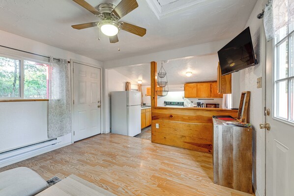 A spacious kitchen with wooden cabinets, a built-in refrigerator, and a ceiling fan. - Grants Pass Cottage ~ 8 Mi to Rogue River! (Grants Pass)