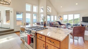 A spacious kitchen with a large island, built-in appliances, and a view of the outdoors. - Luxury Modern Retreat: 40 Acres and Mountain Views (Glenwood Springs)