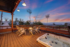 A wooden deck with a hot tub, chairs, and a fire pit. - Luxury Modern Retreat: 40 Acres and Mountain Views (Glenwood Springs)