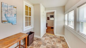 A hallway with a wooden bench, a trash can, and a door leading to another room. - Near Talimena State Park: Quiet Talihina Getaway (Talihina)