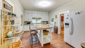 A kitchen with white cabinets, a wooden island, and a refrigerator. - Near Talimena State Park: Quiet Talihina Getaway (Talihina)