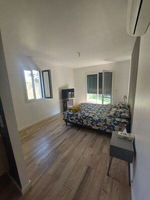 A bedroom with a bed, a bedside table, a TV, and a window. - Villa Plain Pied (Fayence)