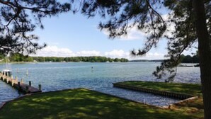A lakeside view with a dock, chairs, and a grassy area. - Minutes from Downtown St. Michaels | Pool | Cabana | Kayaks | Private Dock (St. Michaels)